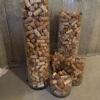 Six glass cylinders full of wine corks. Cylinders vary in size