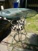 Round Glass Outdoor Patio Table with Ornamental Metal Leaf Base