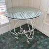 Round White Metal Patio Table with Tempered Glass Top and Ornate Design