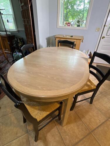 Oval Wood Dining Table with Four Black Ladder Back Chairs