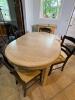 Oval Wood Dining Table with Four Black Ladder Back Chairs