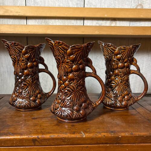 Trio of Brown Embossed Ceramic Pitchers With Grapevine Motif