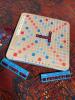 Scrabble Board Game with Maroon Letter Tiles and Blue Racks