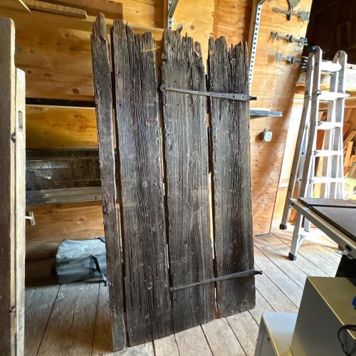 Weathered Wood Plank Door with Jagged Top and Iron Straps